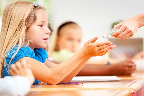 child-applying-hand-sanitizer-in-classroom